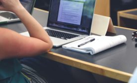 Person Sitting in Front of the Laptop Computer